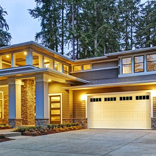 Luxurious new construction home exterior with two garage spaces and wide driveway at sunset. Northwest, USA